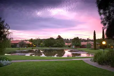 Cherry Tree Grove Retirement Living community lake outside at dusk with walking paths